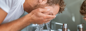 Warmwasserbereitung: Mann wäscht sein Gesicht mit Wasser
