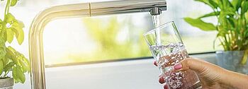 Frischwasserstation: Trinkwasser wird in Glas gefüllt