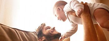Schimmel vorbeugen: Mit optimalem Raumklima zum Ziel Schimmel vorbeugen und Raumklima verbessern: Vater mit Baby auf Couch
