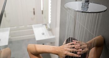 Durchlauferhitzer entkalken: Frau unter Dusche