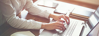 Fördermittelauskunft Tool: Finden Sie Ihre Förderprogramme online Online-Tool Fördermittelauskunft: Frau tippt auf Laptop an Schreibtisch