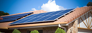 Sonnenstrom vom Dach: Die Definition von Photovoltaik Photovoltaik Definition: Solarmodule auf Hausdach in Sonne