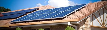 Sonnenstrom vom Dach: Die Definition von Photovoltaik Photovoltaik Definition: Solarmodule auf Hausdach in Sonne