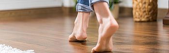 Wartung der Fußbodenheizung: Füße auf Holzfußboden