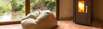 Pelletsverbrauch: So berechnen und reduzieren Sie ihn Pelletsverbrauch: Sitzsack vor Kaminofen
