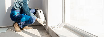 Heizungssanierung Heizungssanierung: Heizungsbauer saniert Heizung vor Fenster