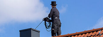 Schornsteinfeger Pflicht: Schornsteinfeger auf Dach