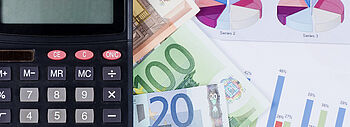 Alte Heizung: Rechtzeitig an die Modernisierung denken Alte Heizung: Taschenrechner und Geld liegen auf ausgedruckten Statistiken und Graphen