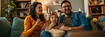 Zirkulationspumpe: Funktionsweise, Vorteile, Betrieb Zirkulationspumpe: Famileie sitzt auf einer Couch und blickt glücklich auf einen Bildschirm