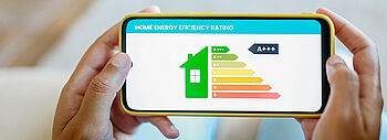 COP der Wärmepumpe: Leistungszahl für die Effizienz COP der Wärmepumpe: Hände halten Smartphone mit Energieeffizienz Grafik