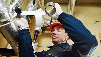 Heizungsrohre dämmen Heizungsrohre dämmen: Handwerker dämmt Rohre