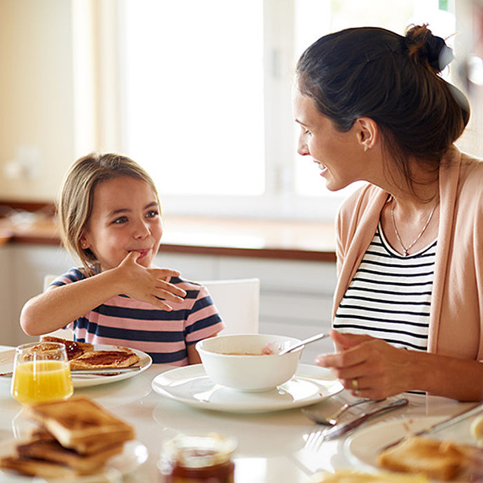 Heizungswartung: Mutter und Tochter lächelnd am Tisch