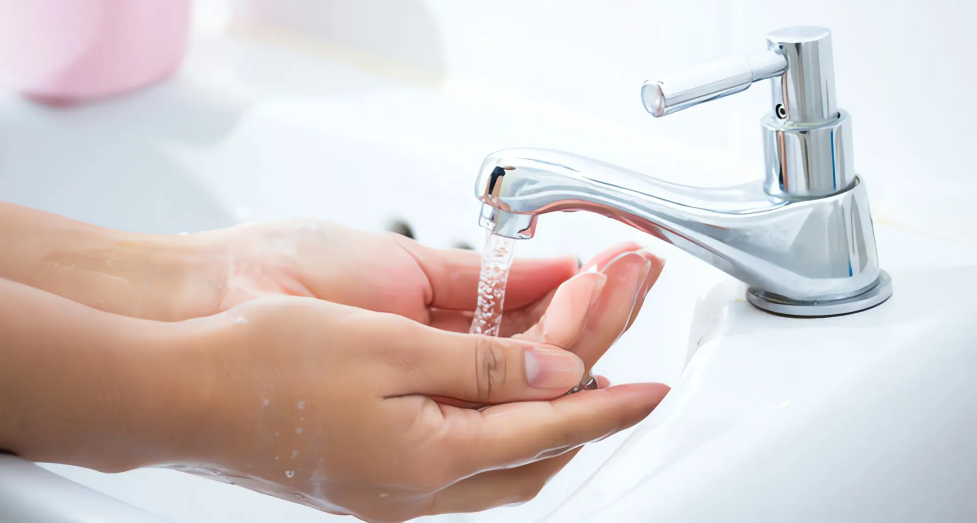 Durchlauferhitzer entkalken: Frauenhände unter Wasserhahn