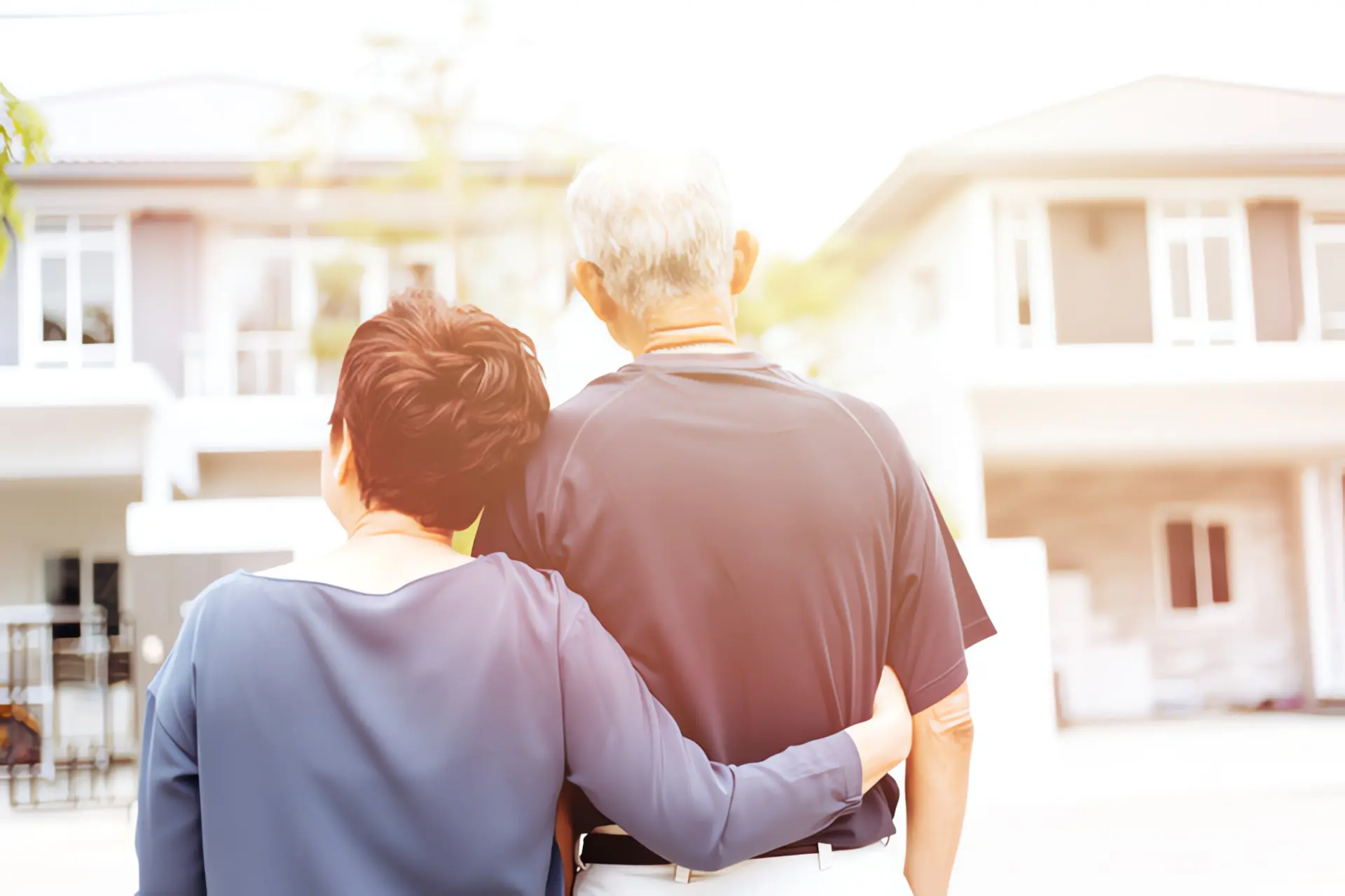 Energetische Sanierungspflicht: Älteres Paar steht vor Einfamilienhaus