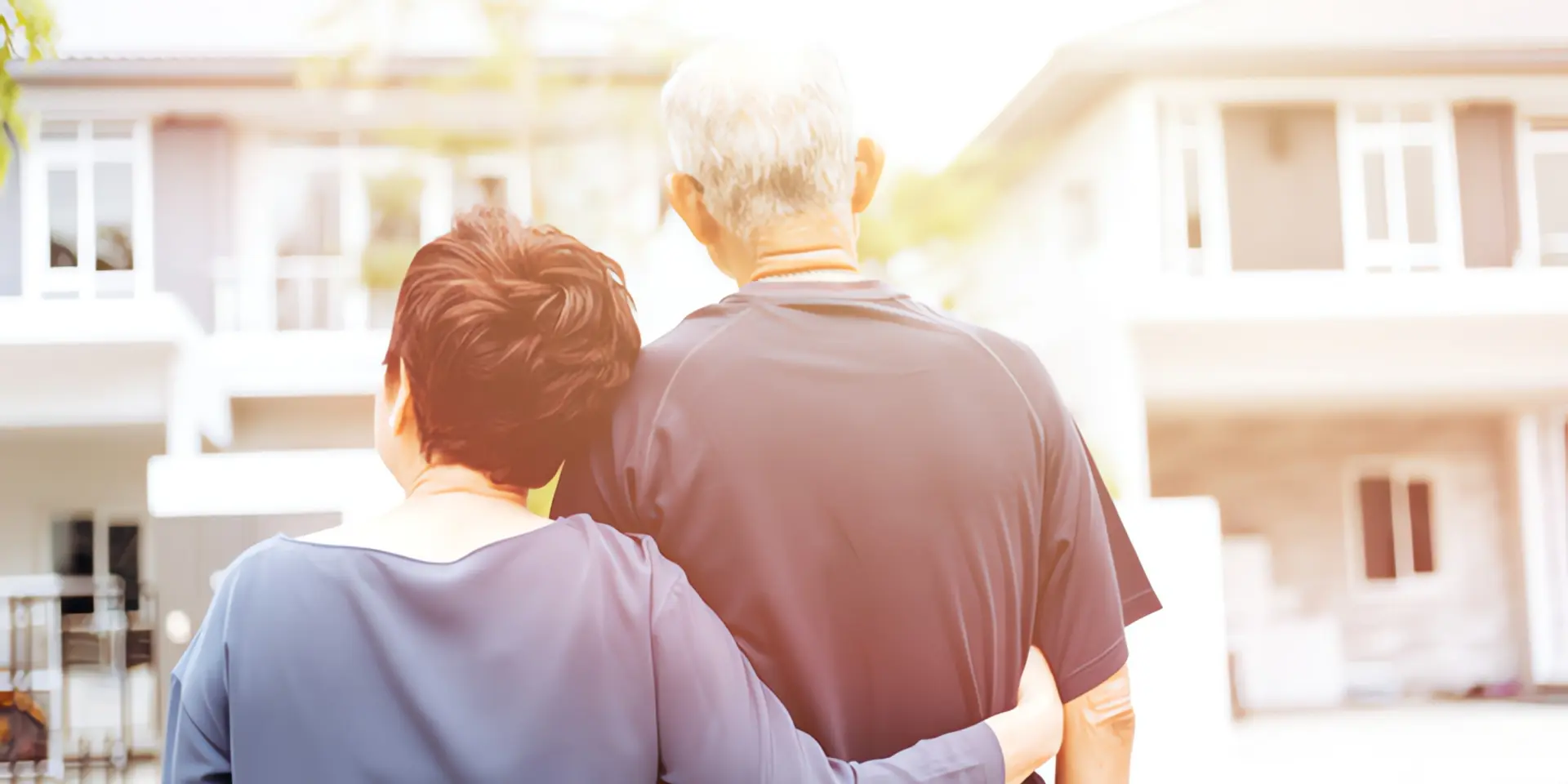 Energetische Sanierungspflicht: Älteres Paar steht vor Einfamilienhaus