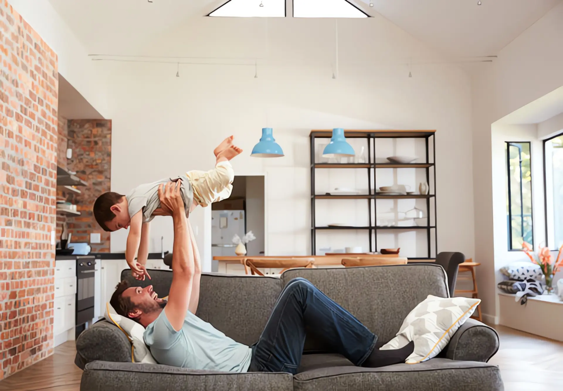 Energie sparen im Haushalt: Mann spielt mit Kleinkind in Wohnzimmer
