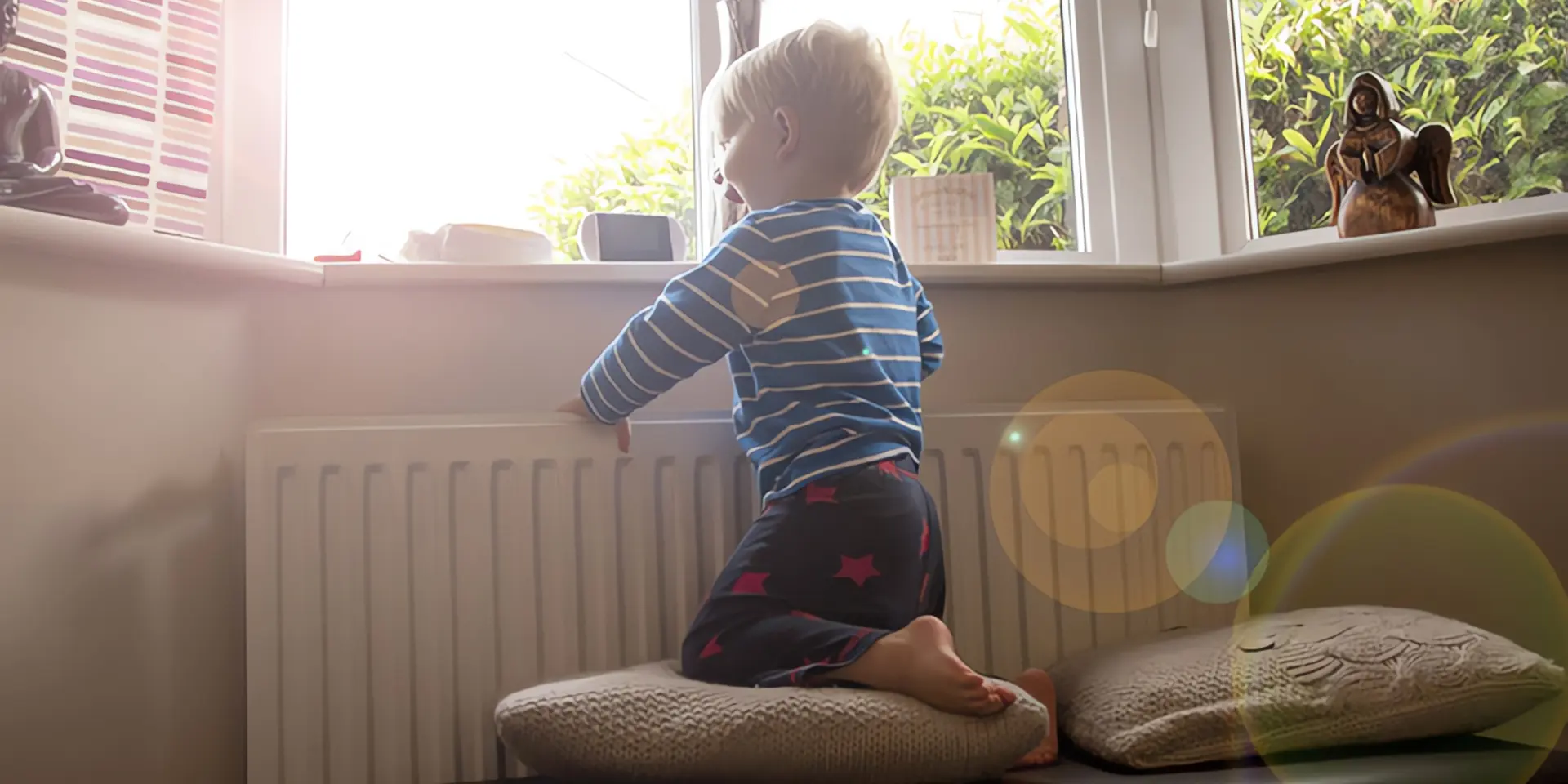 Heizen mit Fernwärme: Kleiner Junge an Fenster