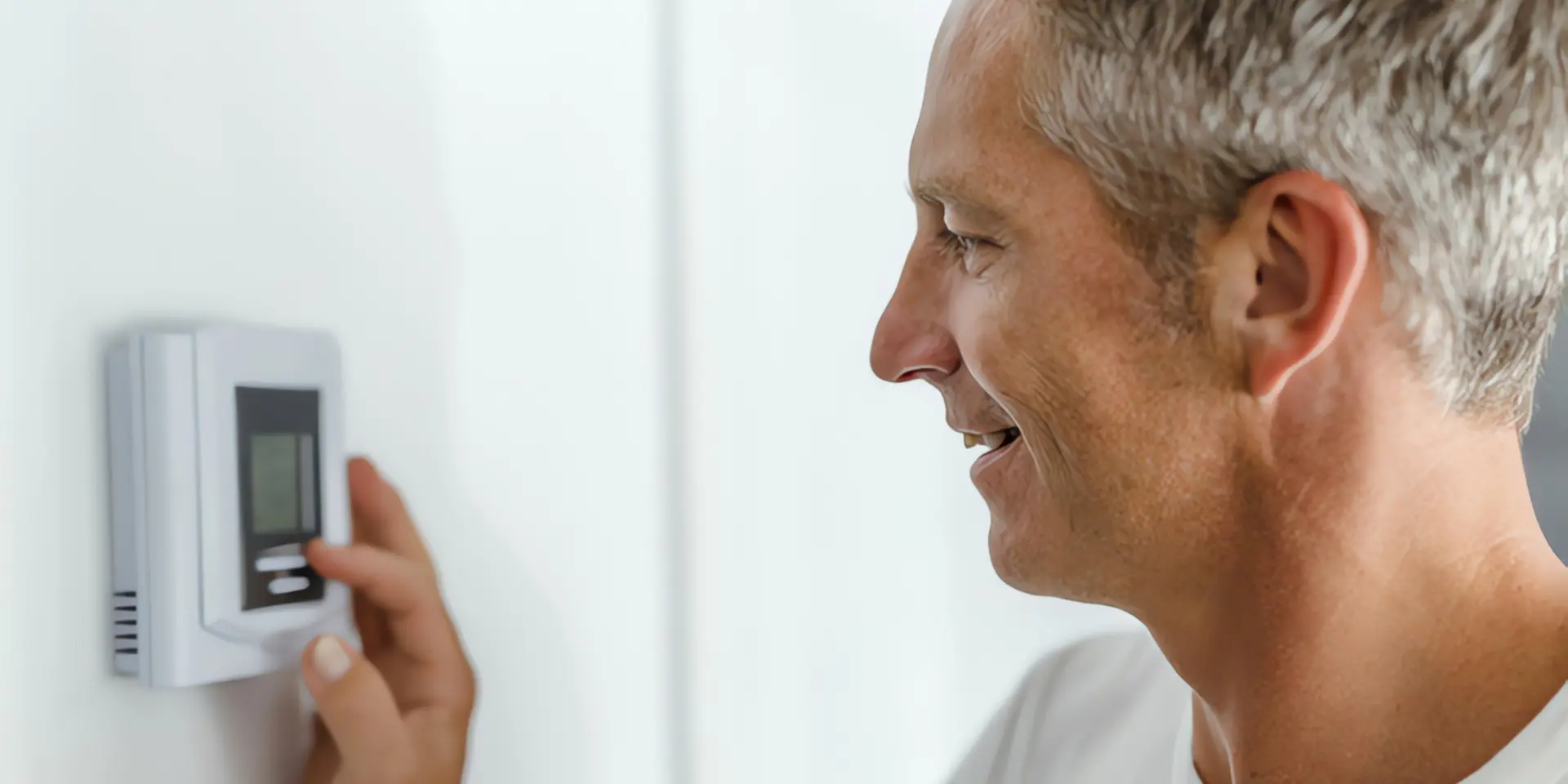 Heizung Keller: Mann stellt Heizungsthermostat ein