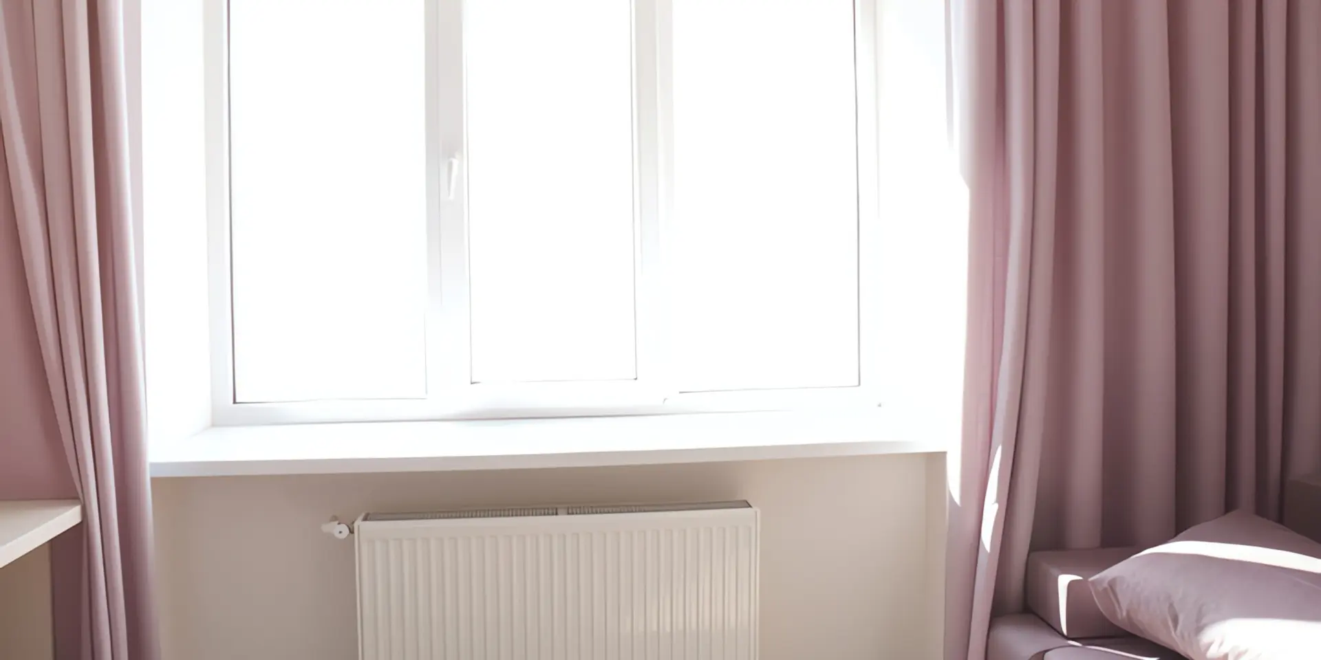 Hydraulischer Abgleich: Heizkörper vor Fenster mit rosa Vorhängen
