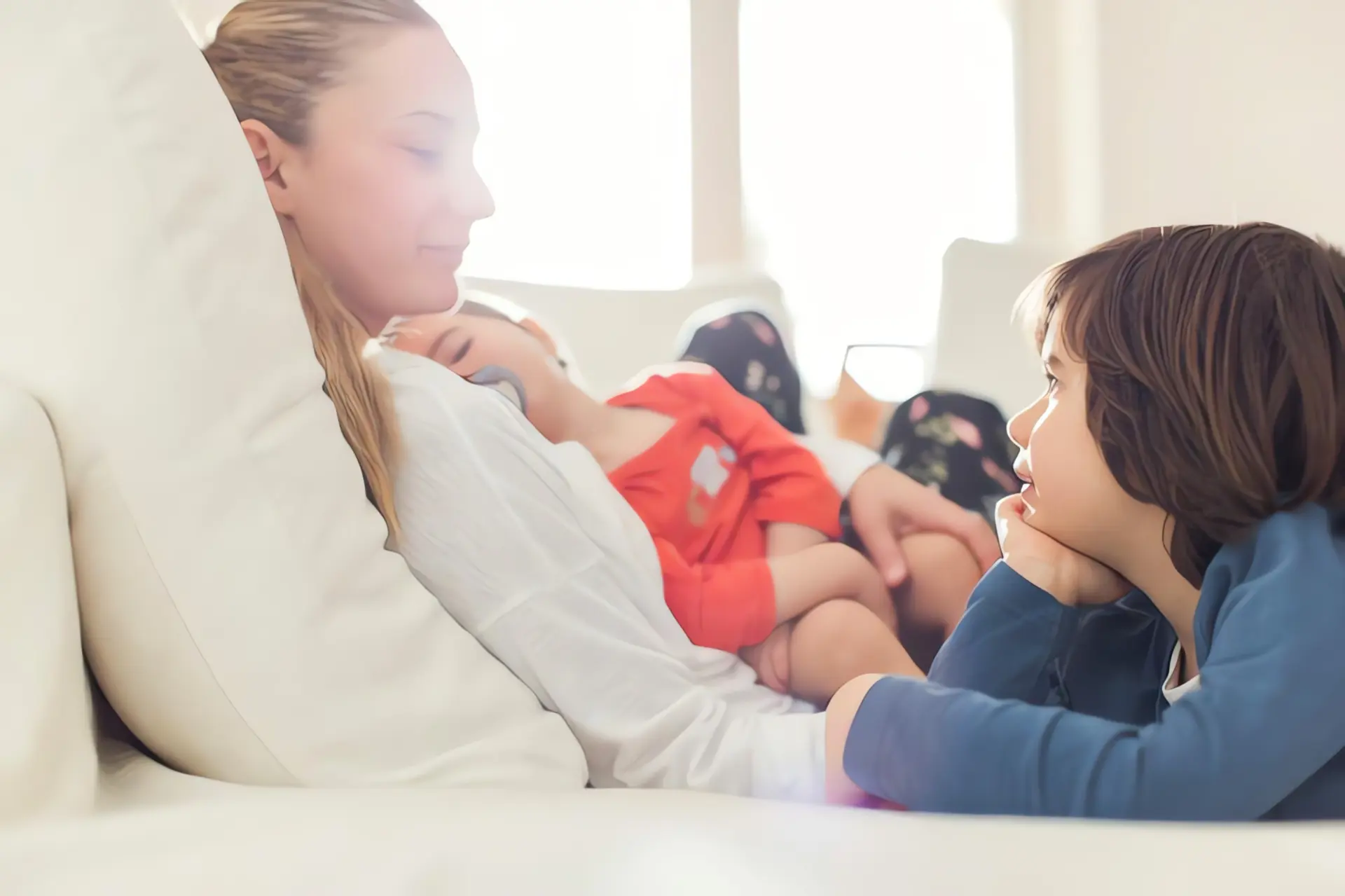 Wie heizt man richtig? Frau und zwei kleine Kinder auf Couch