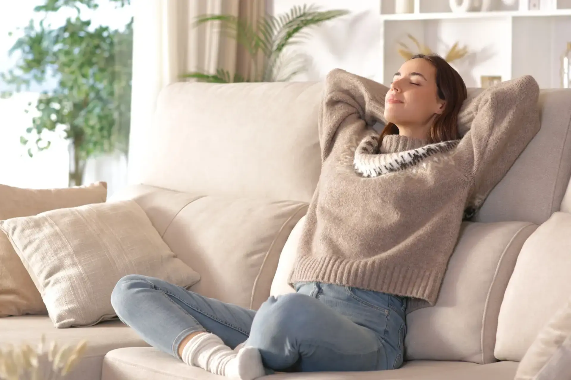 Stromverbrauch Lüftungsanlage: Frau sitzt entspannt auf dem Sofa