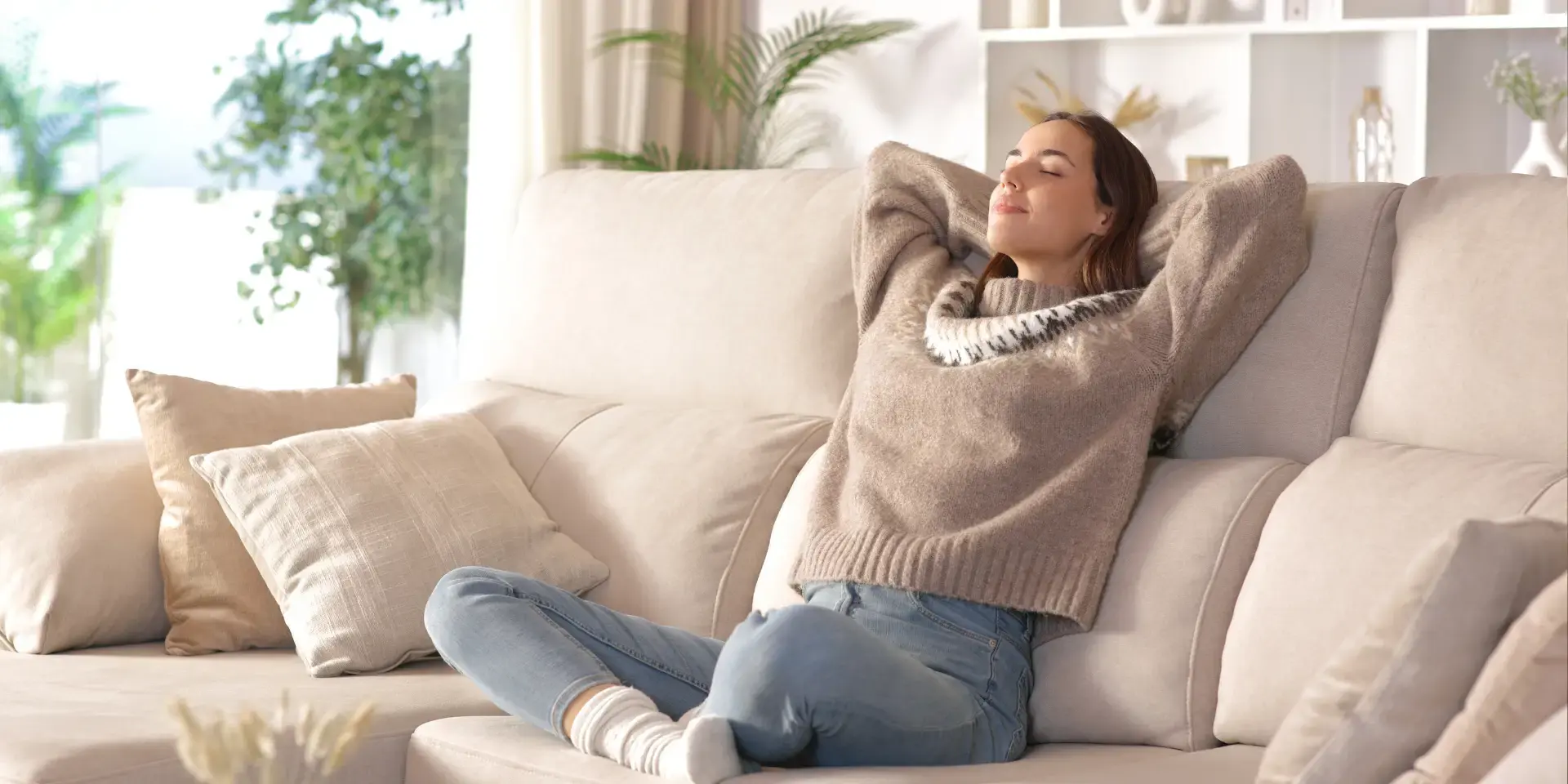 Stromverbrauch Lüftungsanlage: Frau sitzt entspannt auf dem Sofa