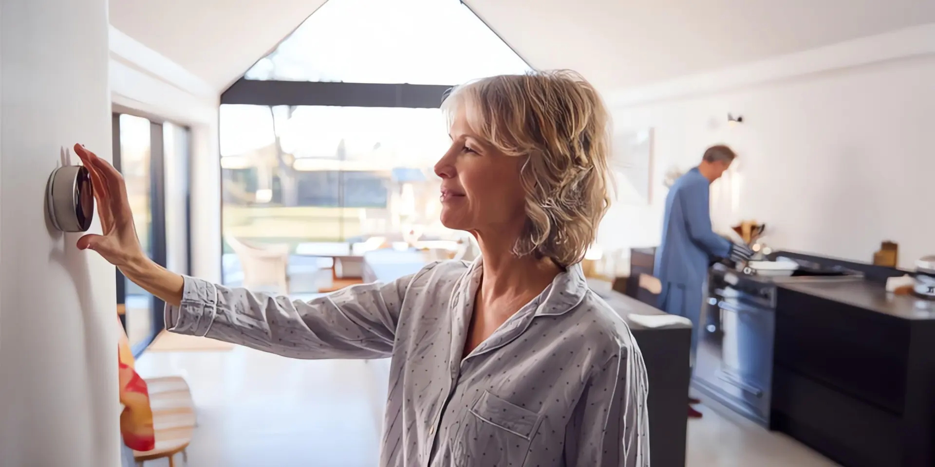 Thermostat: Frau stellt Heizugsthermostat ein