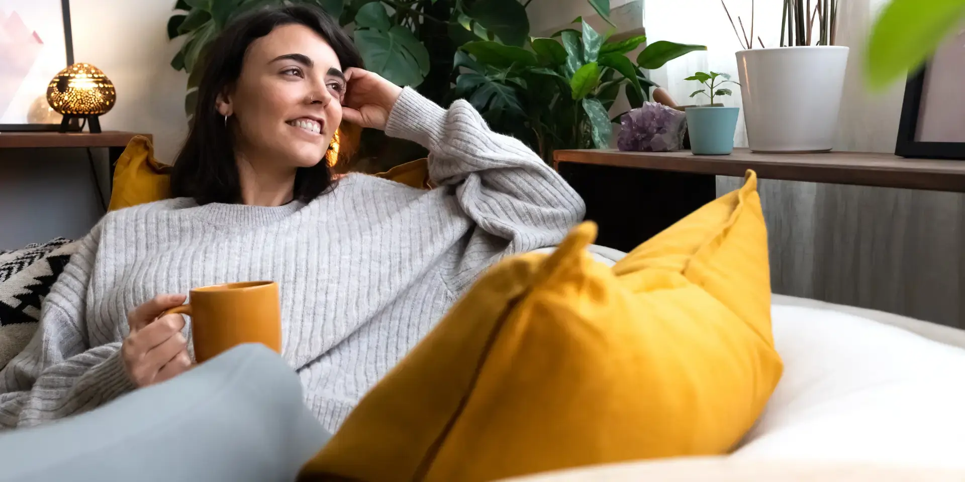 Vor und Nachteile Fernwärme: Lächende Frau auf dem Sofa