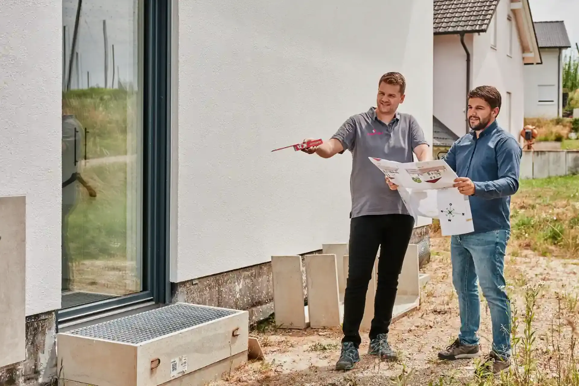 Wärmepumpe Beratung: WOLF Fachexperte mit Hausbauer auf Baustelle