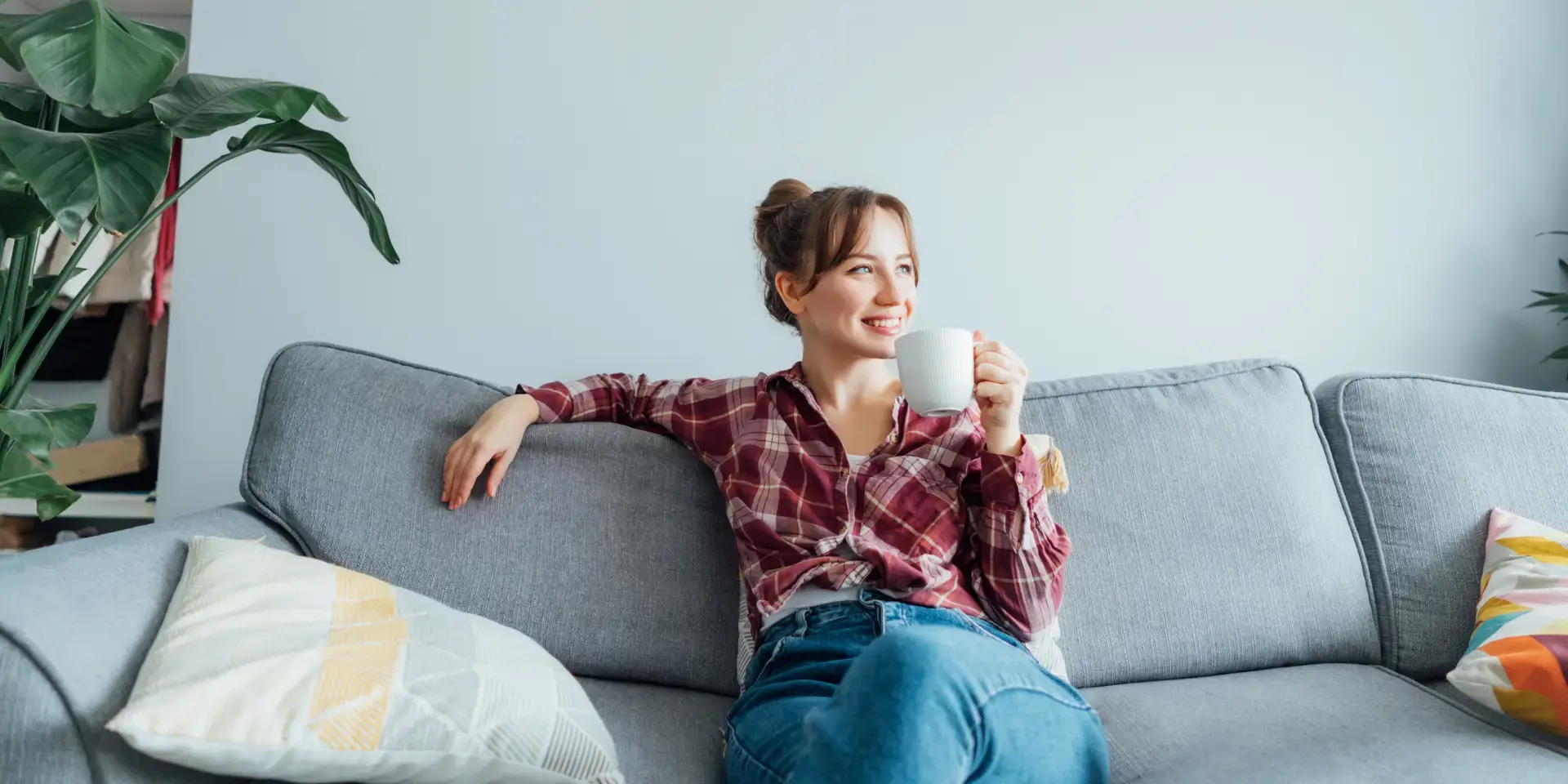 Lächende Frau auf einem Sofa Wärmepumpe Bivalenzpunkt