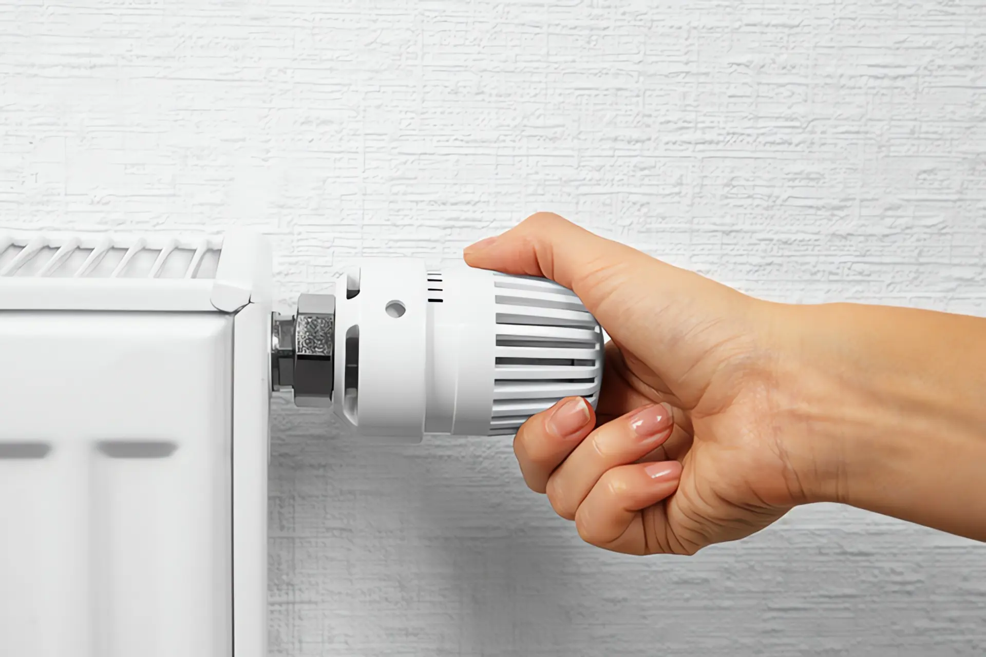 Wärmepumpe Heizkörper: Hand dreht an Heizungsthermostat