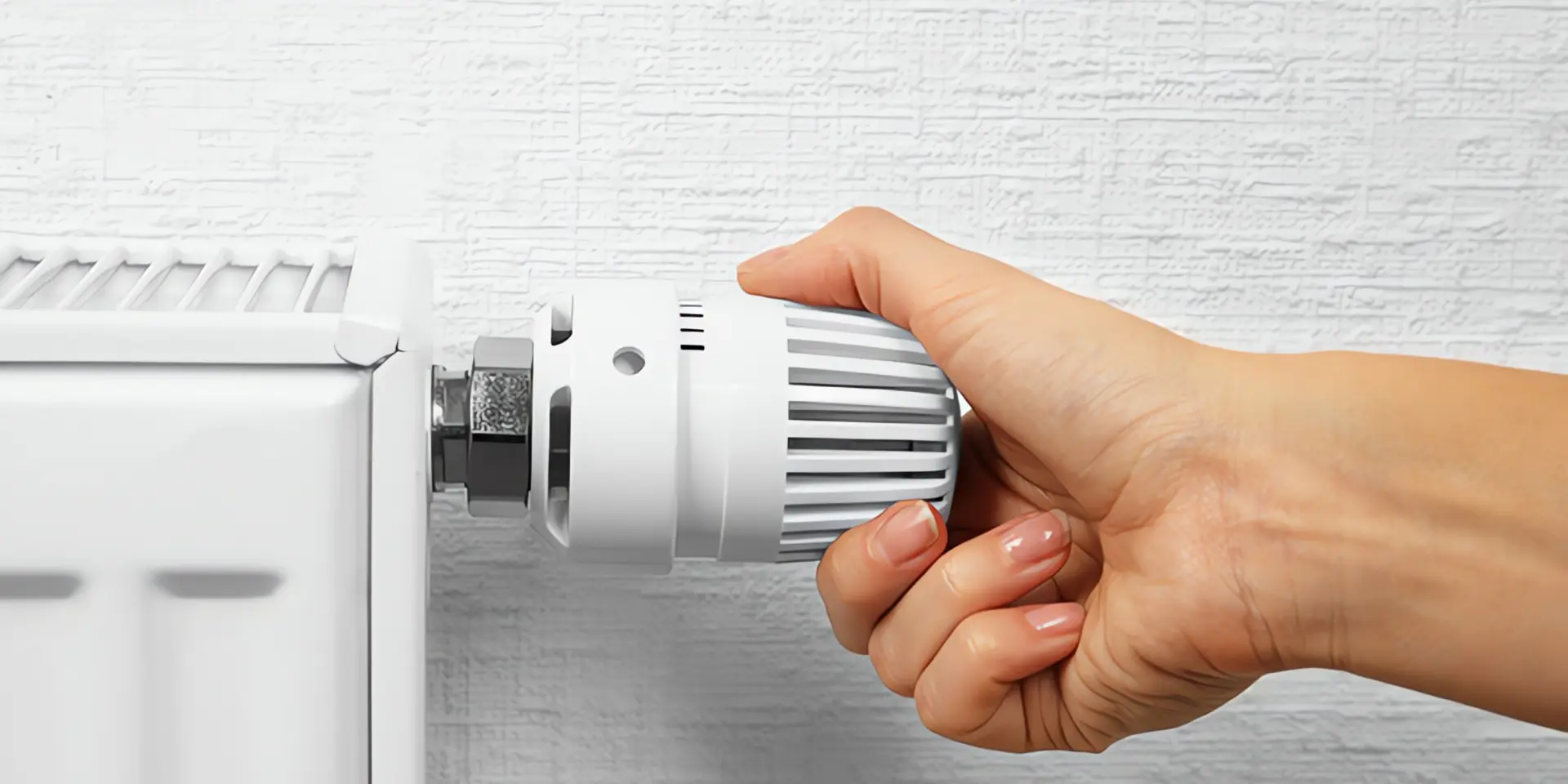Wärmepumpe Heizkörper: Hand dreht an Heizungsthermostat