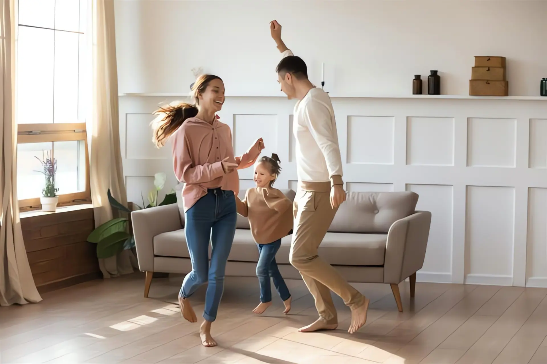 Glückliche Familie tanzt im Wohnzimmer mit Fußbodenheizung