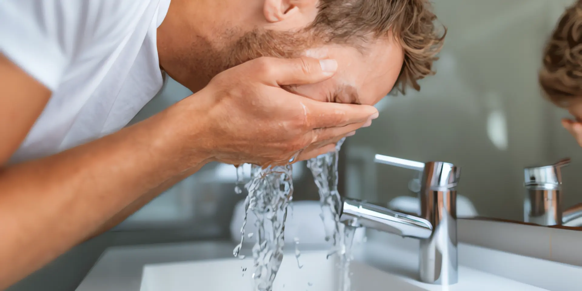 Warmwasserbereitung: Mann wäscht sein Gesicht mit Wasser