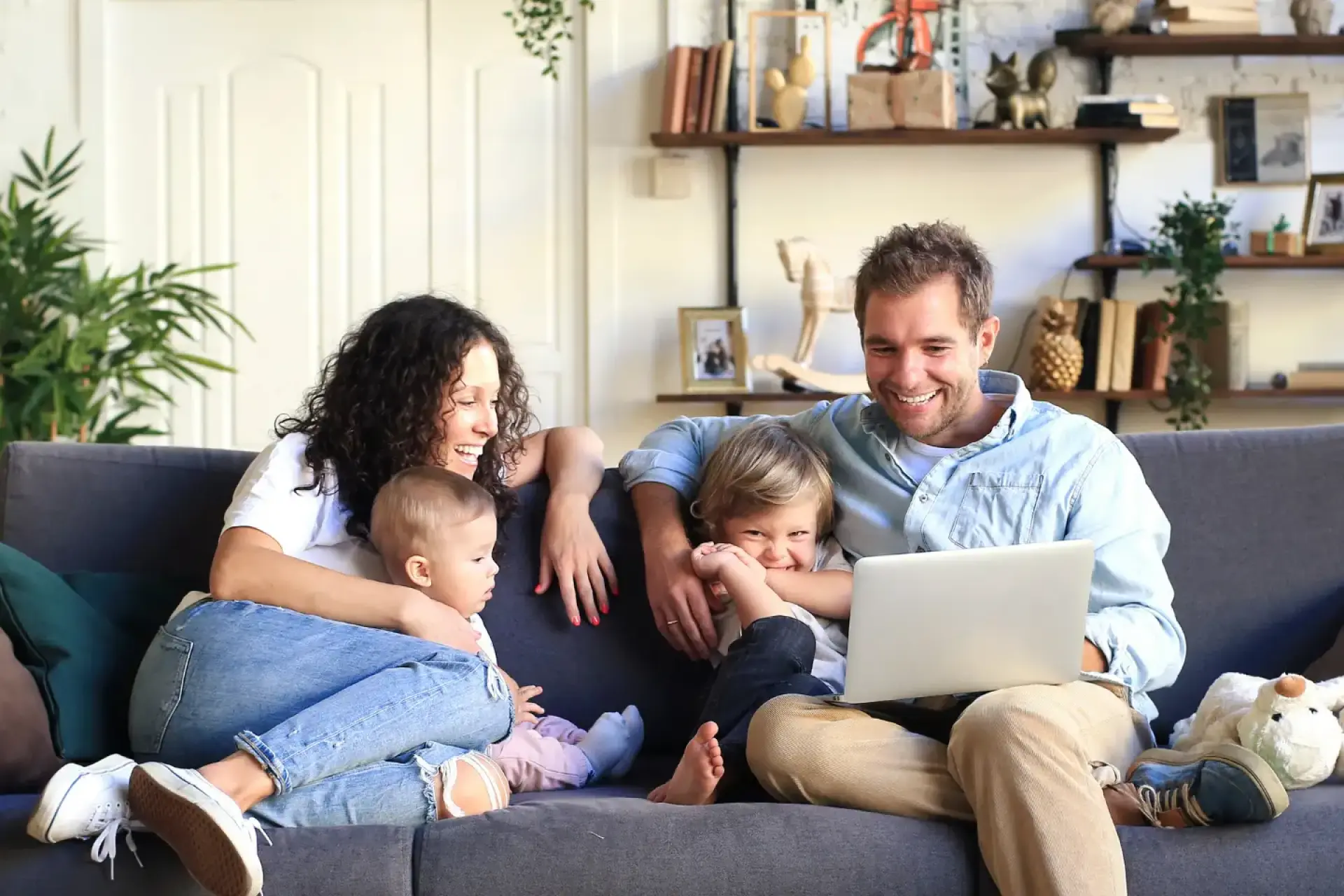 Fröhliche Familie sitzt auf dem Sofa SCOP der Wärmepumpe