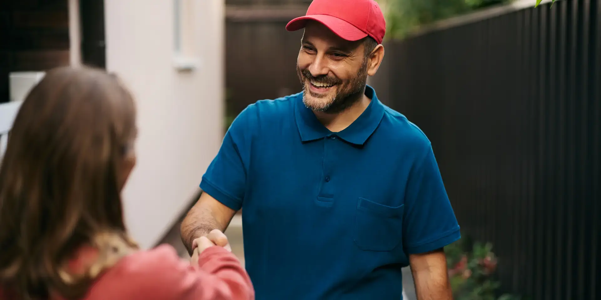 wartung lüftungsanlage: Fröhlicher Handschlag zwischen Kunde und Fachmann (Mann mit einer Kappe)